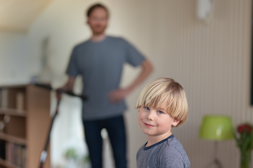 Gutt med pappa og elsparkesykkel i bakgrunnen