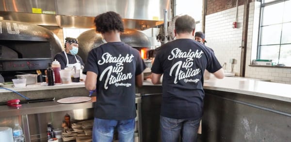 2 employees working together in the Kitchen at Fortina Pizza