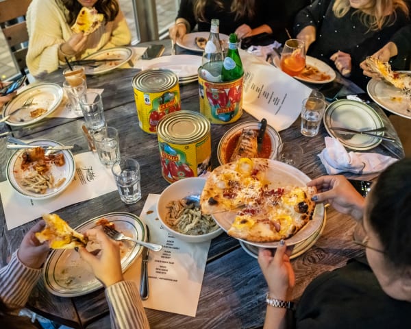 People gathered around a table, enjoying food at Fortina Pizza