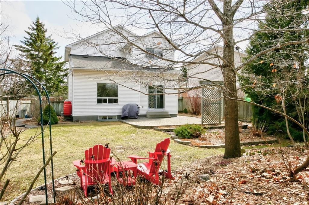 Exterior of a house, including backyard and red Muskoka chairs