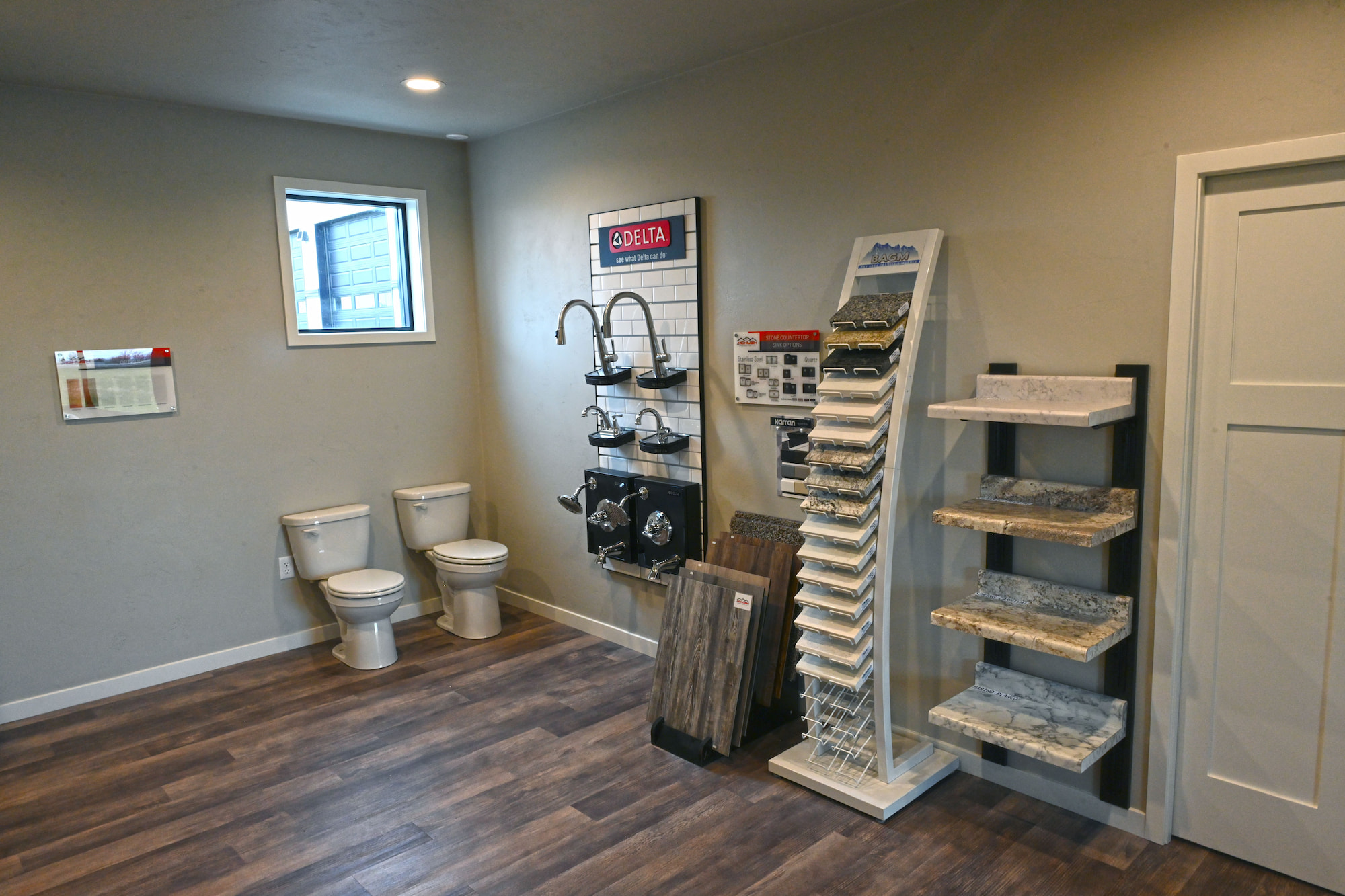 Interior showroom featuring countertop samples, flooring, and plumbing fixtures at a commercial construction office