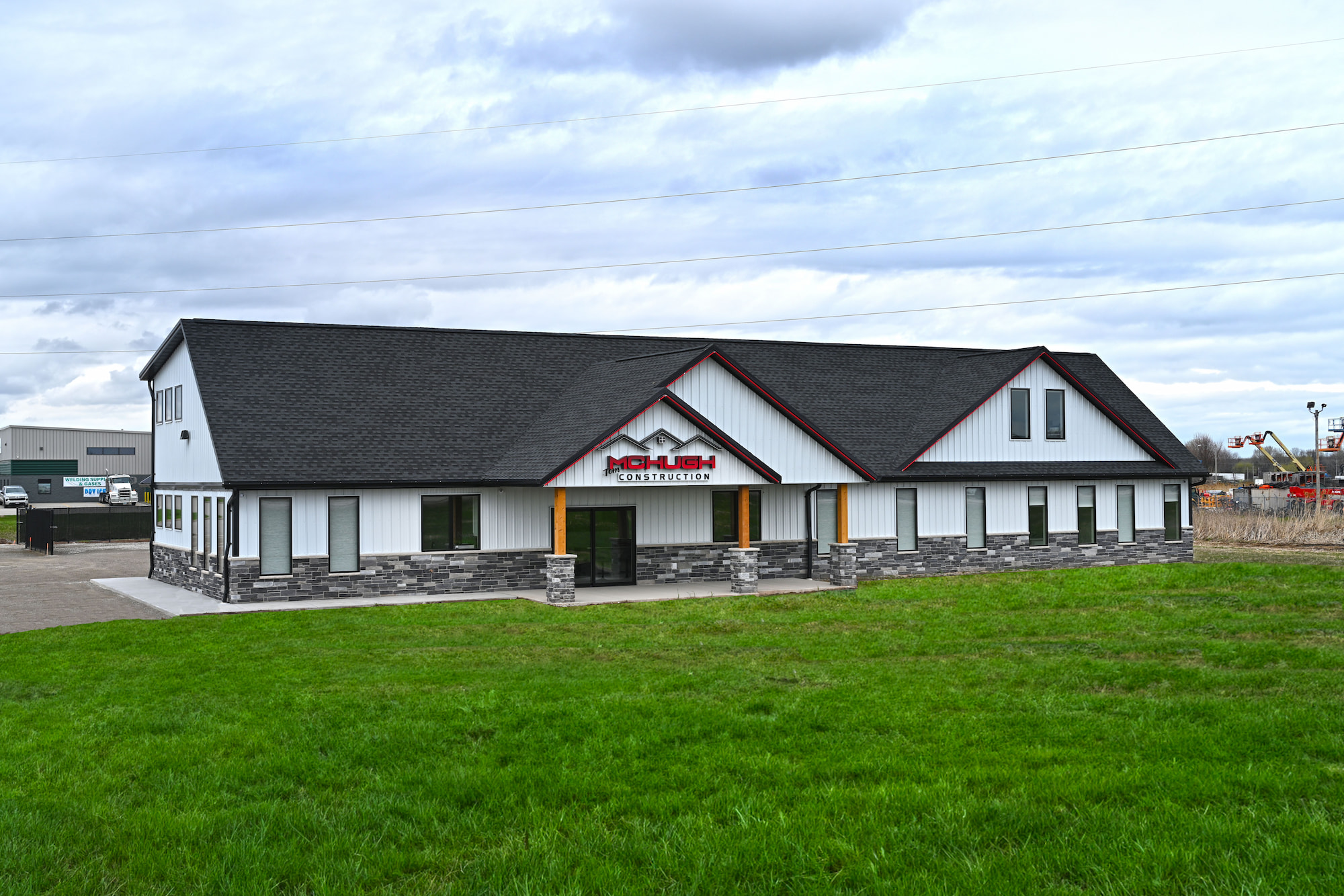 Front left facing view of a newly completed commercial construction office building with stone and siding exterior