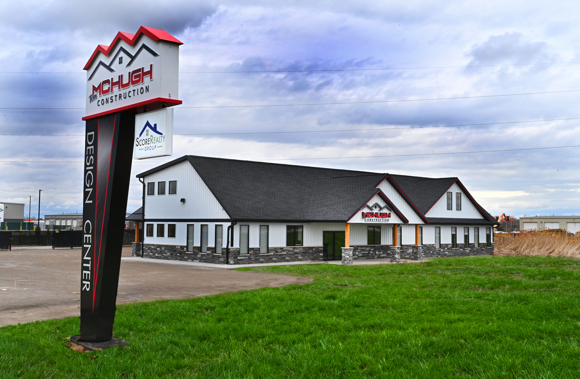 Front left facing view of a newly completed commercial construction office building with sign along driveway