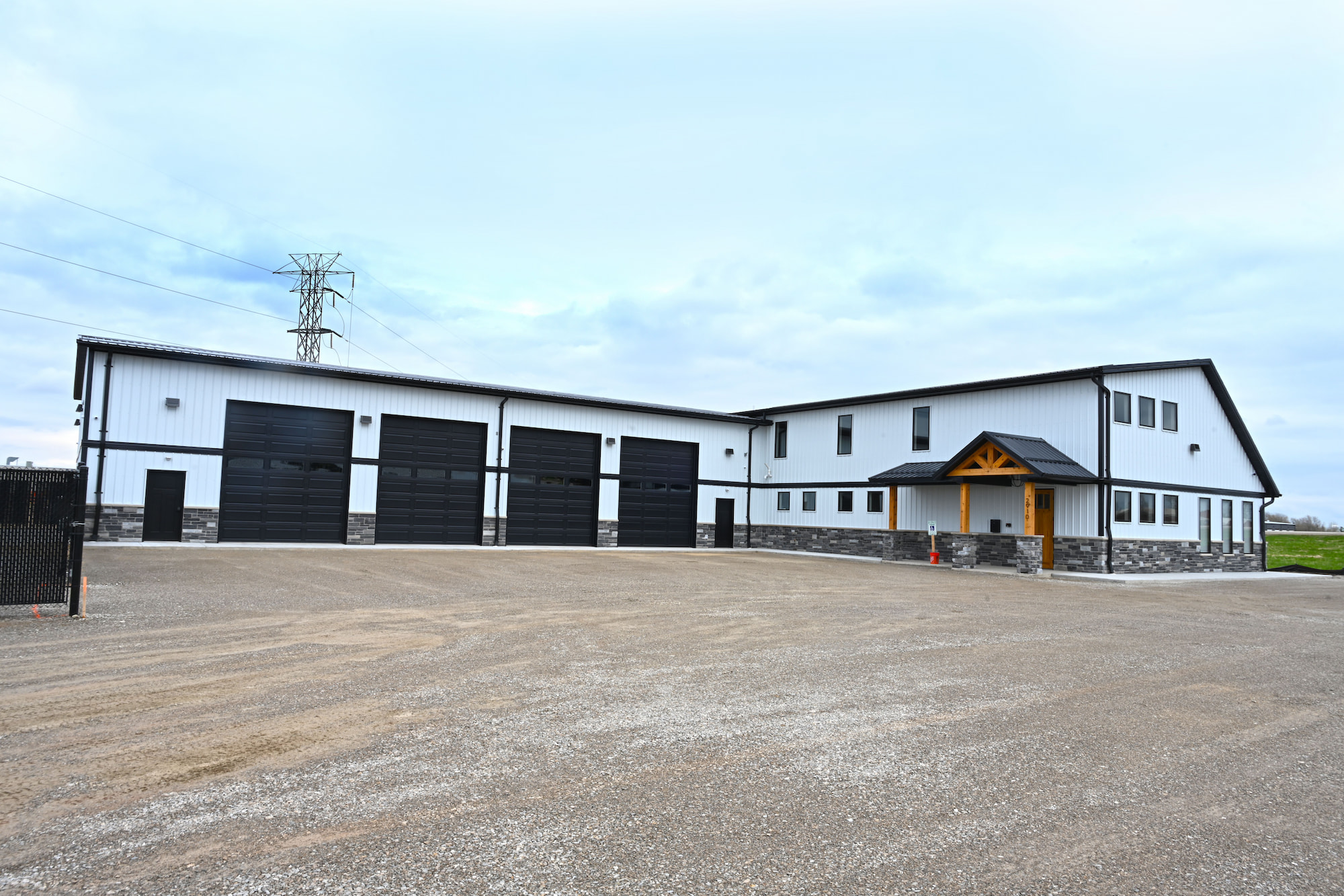 Back view of a newly completed commercial construction office building with four large overhead garage doors