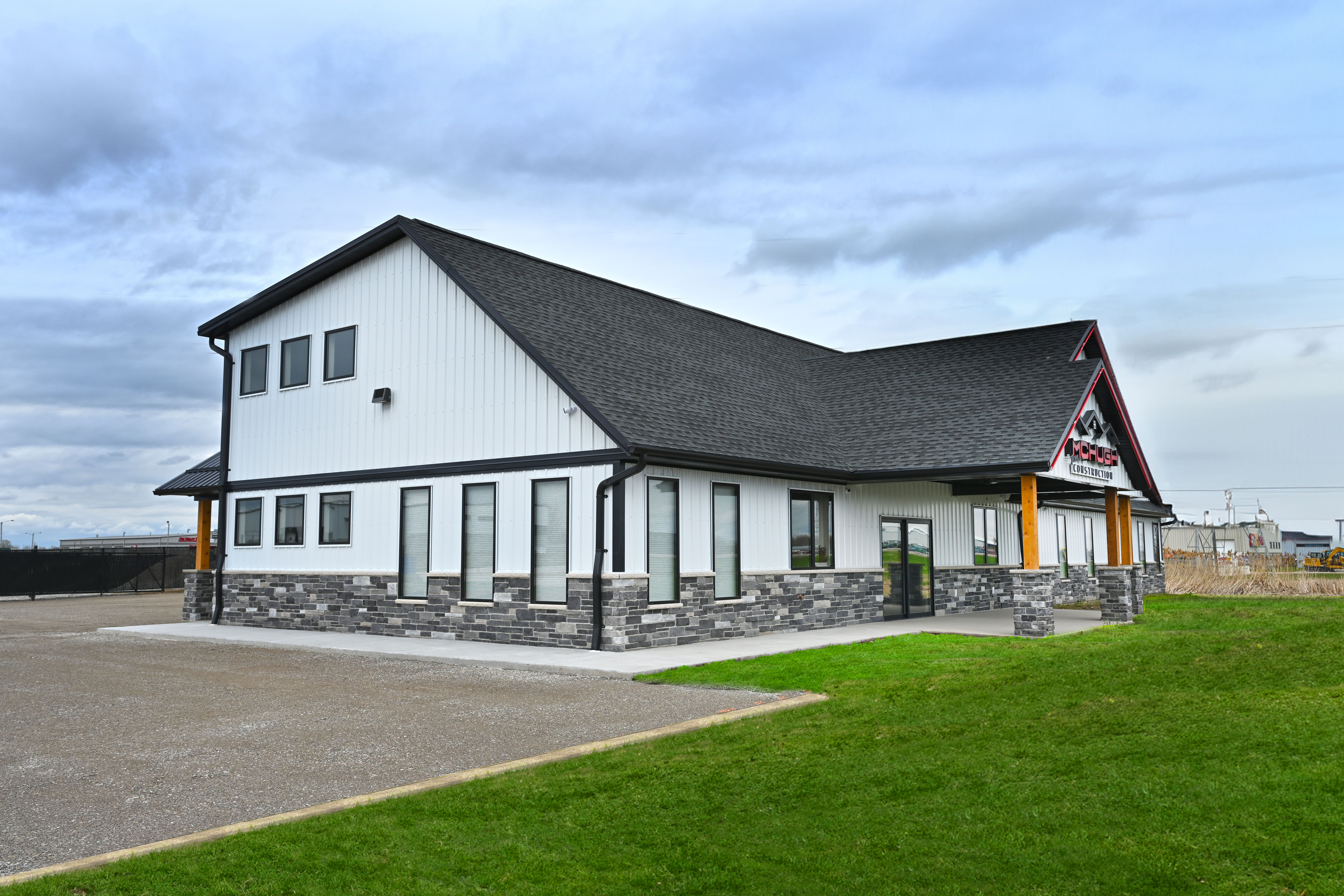 Front left facing view of a newly completed commercial construction office building with stone and siding exterior
