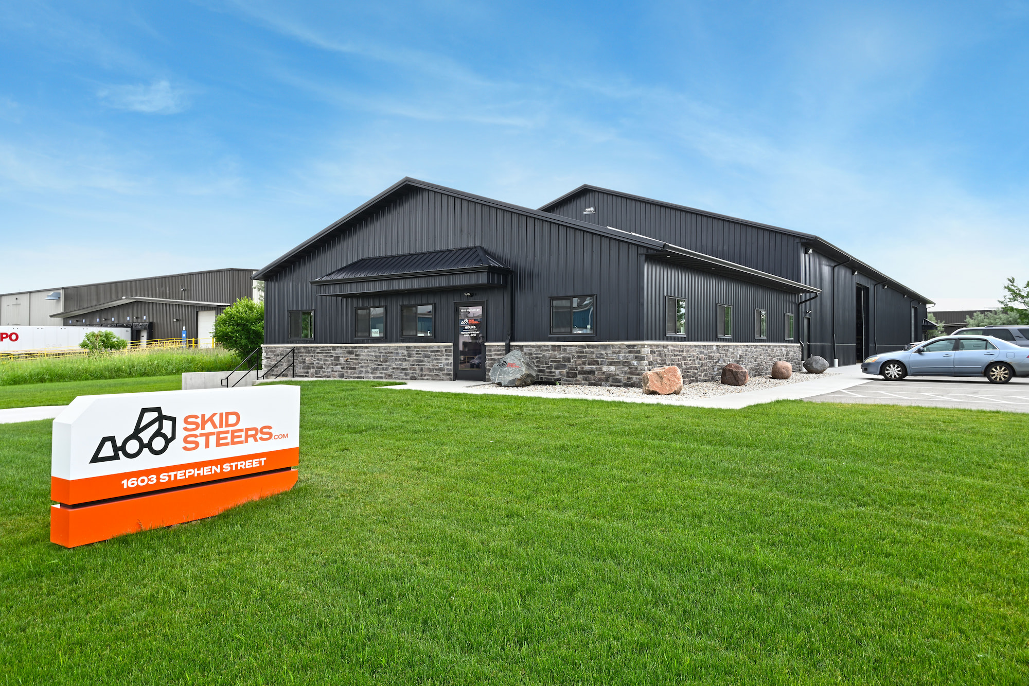 Custom black steel warehouse and office building for SkidSteers.com in Little Chute, WI, built by Fox Structures.