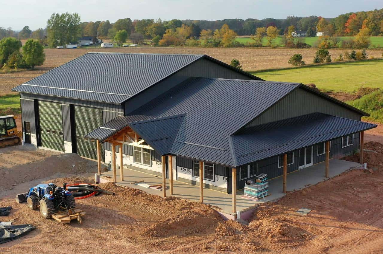 A modern style shouse with an oversized garage and wrap around covered porch