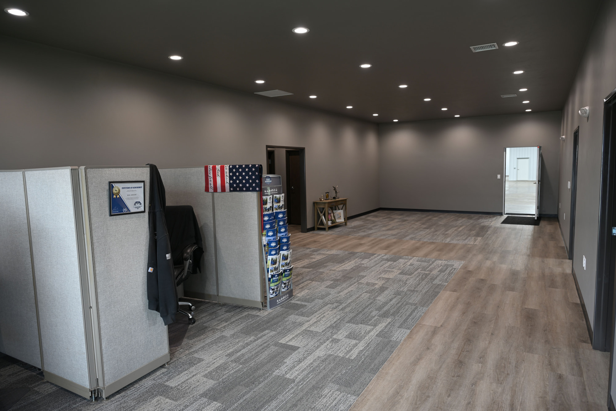 Open office area at SkidSteers.com with cubicles, carpet tile flooring, and recessed lighting.