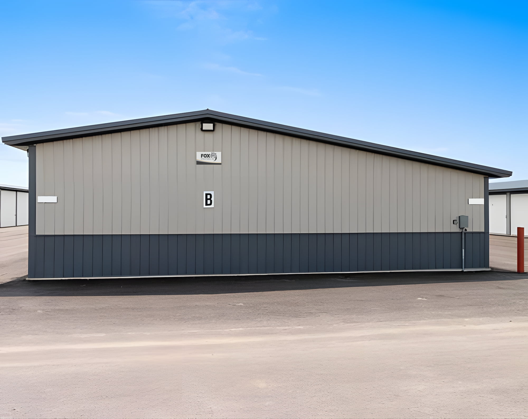 A gray storage building with a metal exterior and a letter "B" on the front.