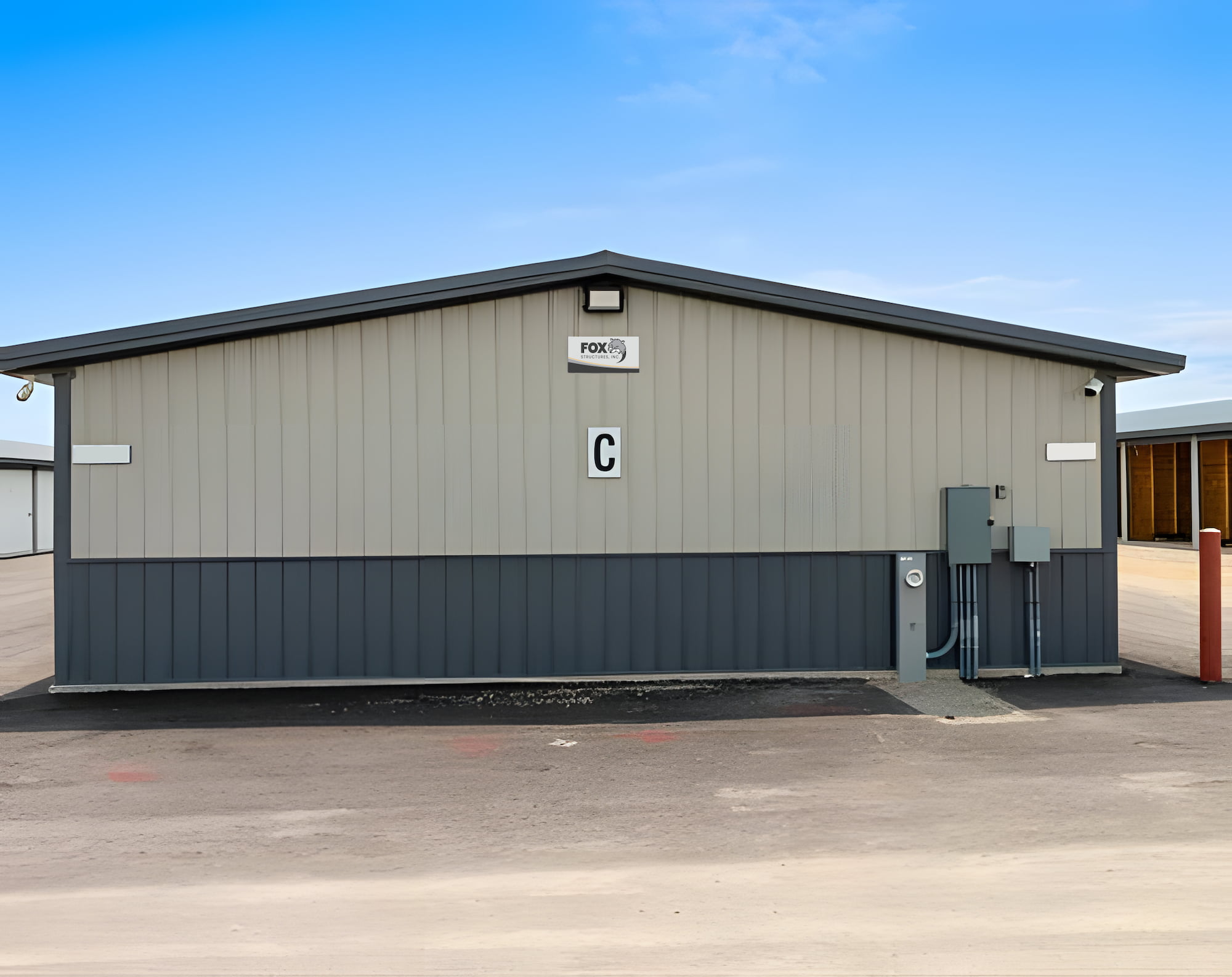 A gray storage building with a metal exterior and a letter "C" on the front.