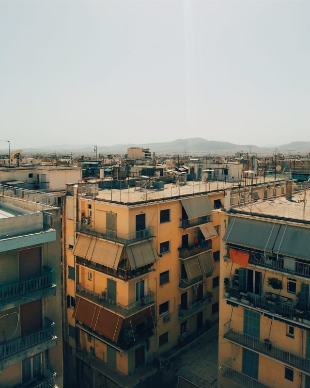 Yellow and gray rooftops, under a scorching sun.