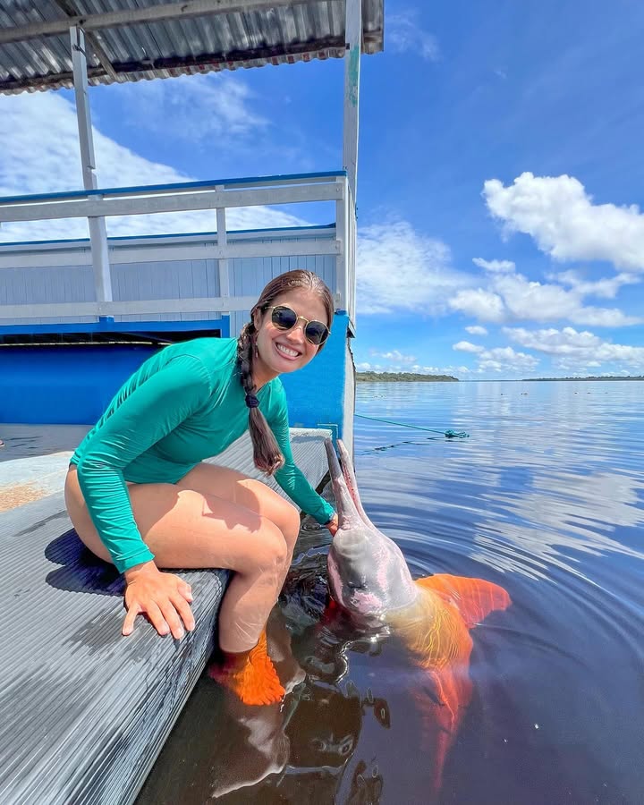 Daihana con un bufeo boliviano (Inia boliviensis) en el muelle del río Ibare, Trinidad, Beni