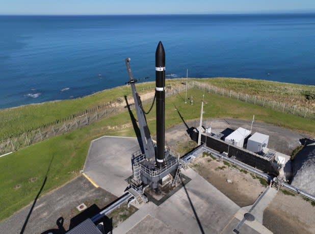 Robotic arm assembling a high-tech satellite component in a Rocket Lab clean room