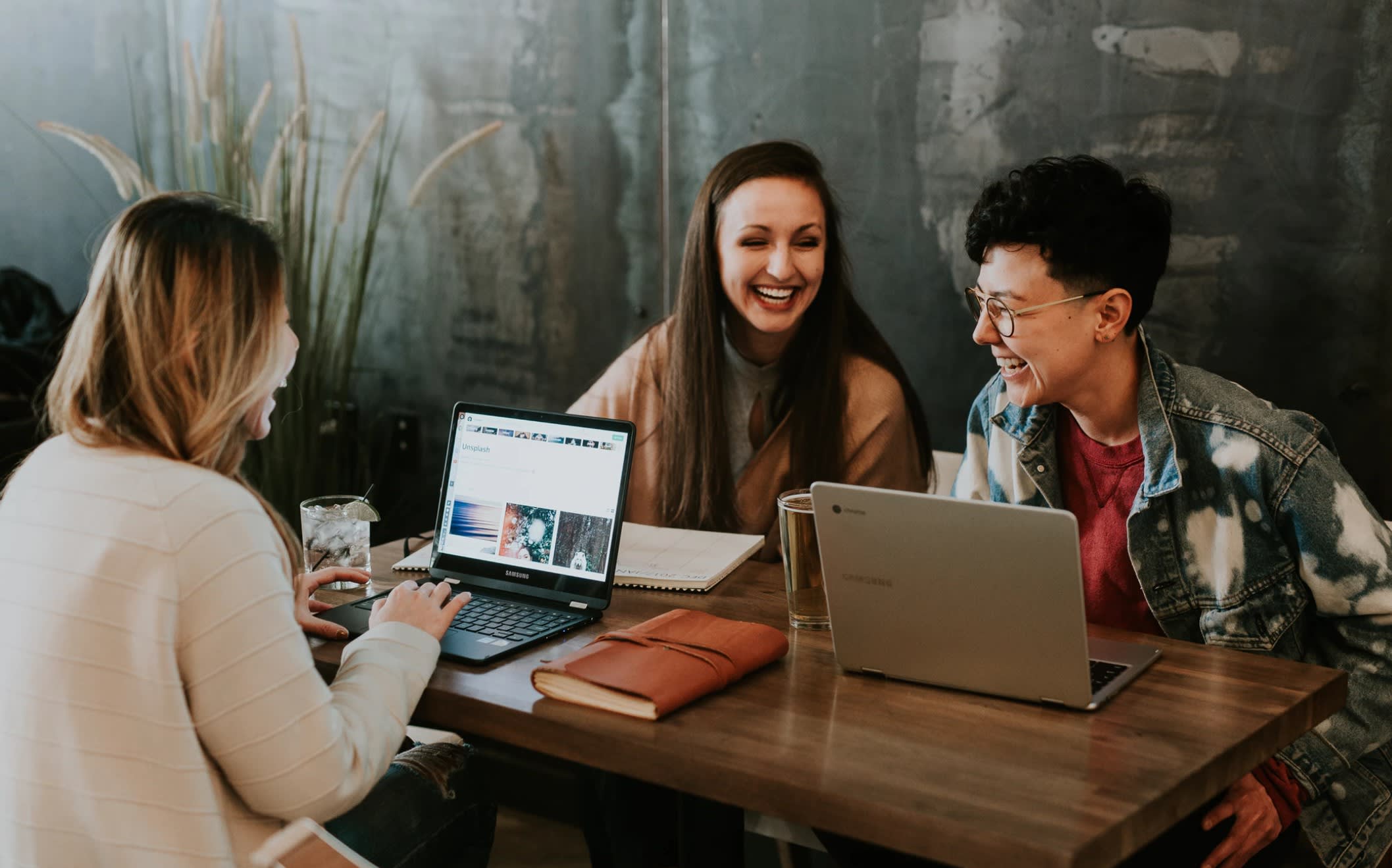 picture of three ladies enjoying a business meeting around a table with laptops and notebooks picture of three ladies enjoying a business meeting around a table with laptops and notebooks
