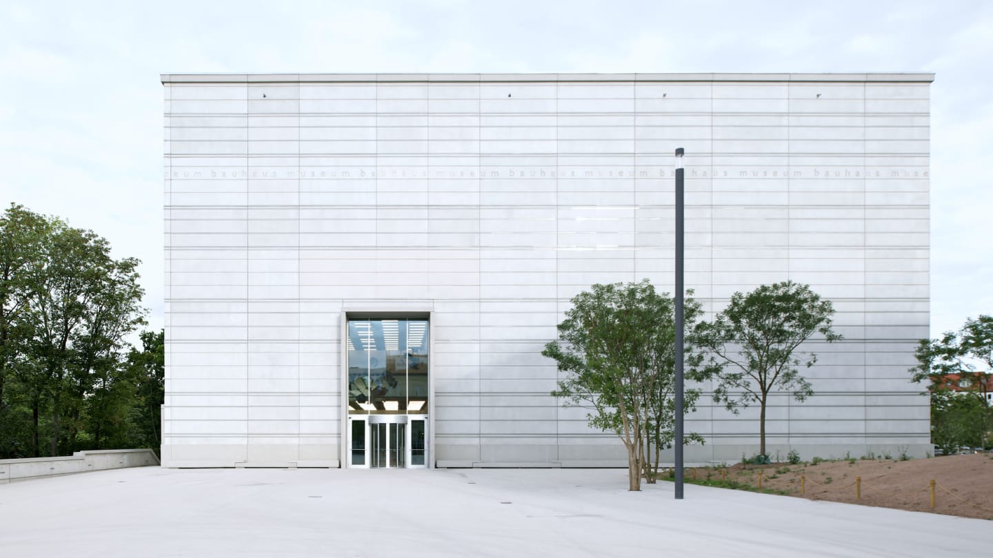 Frontal view of the Bauhaus Museum Weimar with clear, minimalist concrete facade and central entrance.