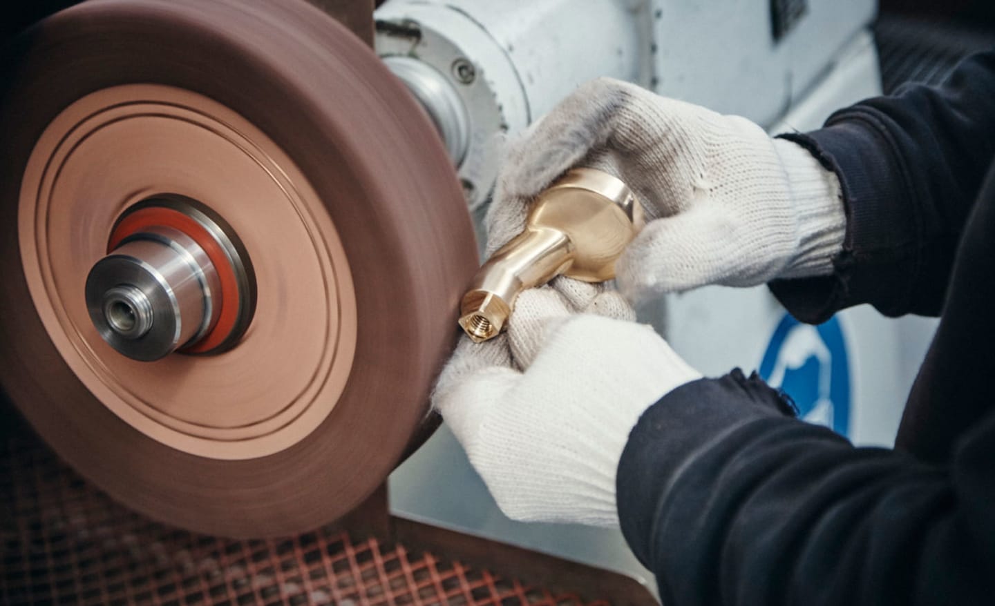 Mitarbeiter poliert in der FSB Produktion in Brakel einen Messingbeschlag an der Schleifmaschine.