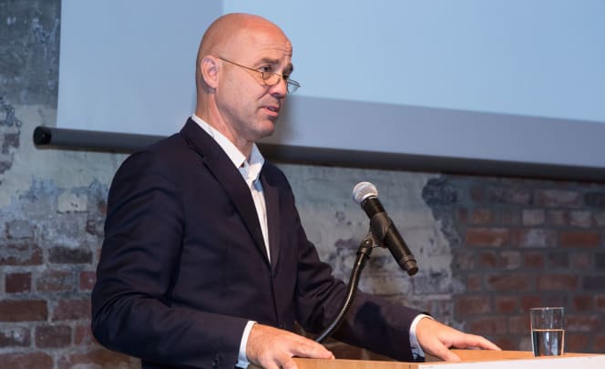 Munich-based architect Andreas Hild speaks at a podium with a microphone during the 2015 Architecture Days