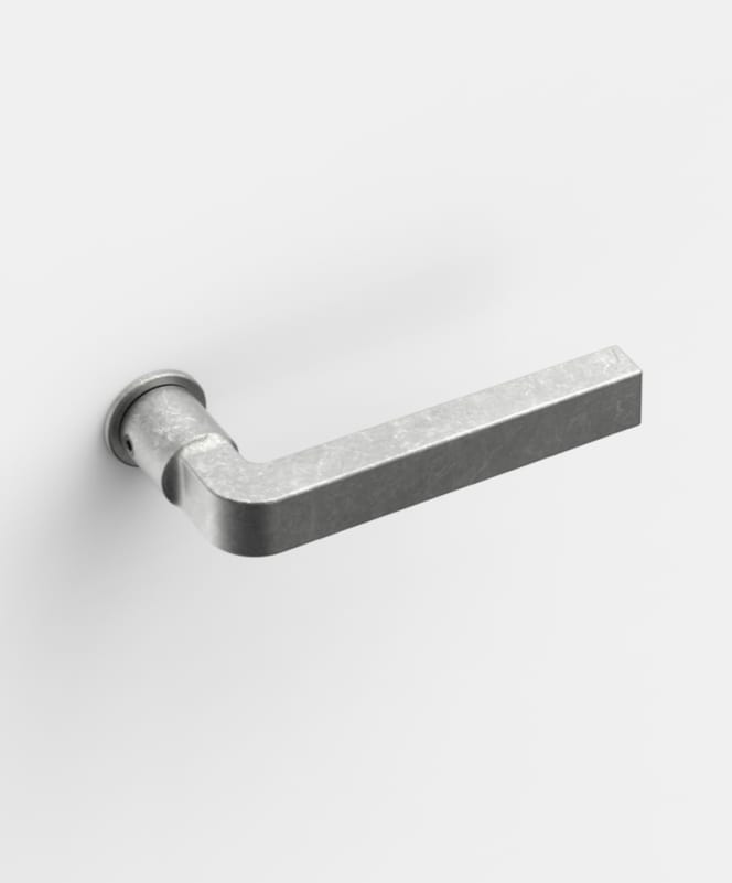View of the FSB door handle model FSB 1004, designed by David Chipperfield, featuring a plug-in grip. The distinctive Aluminum Pure surface particularly enhances the form – a round neck transitions into a square section that continues along the handle through a gently curved joint.