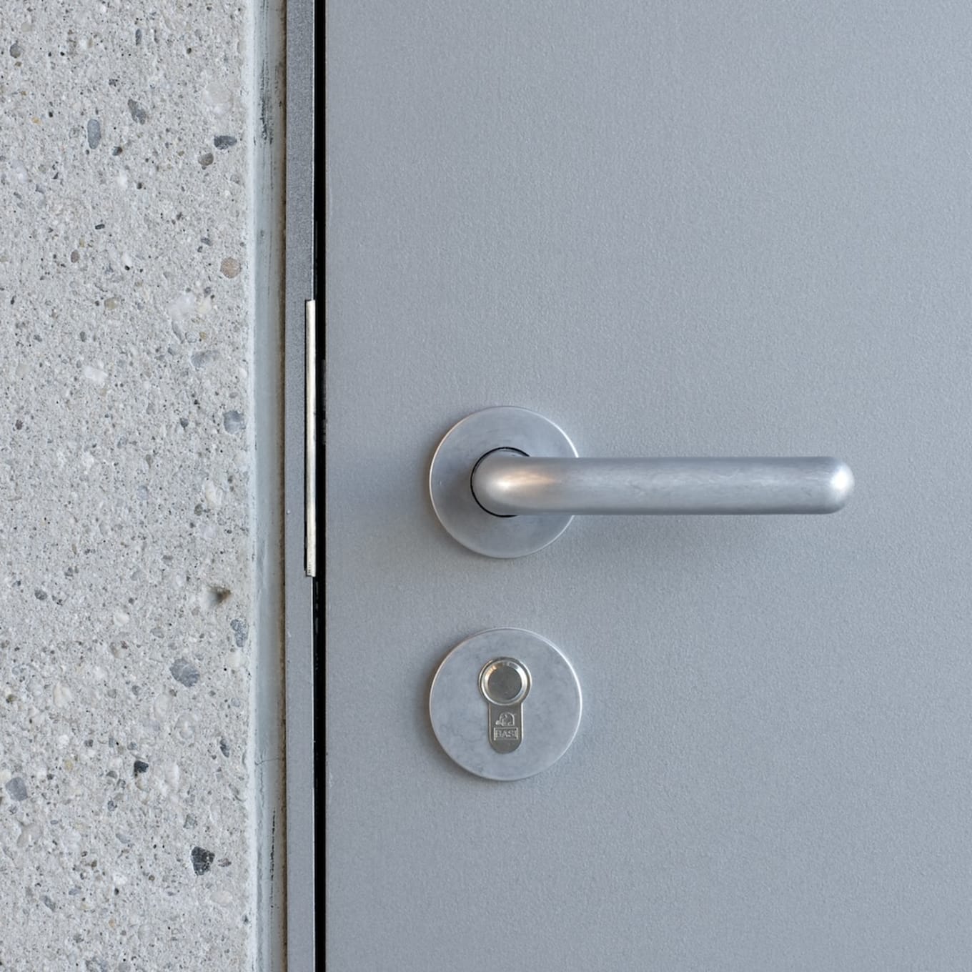 Close-up of an FSB 1147 Wittgenstein Aluminum Pure door handle on a grey door at the Bauhaus Museum Weimar.