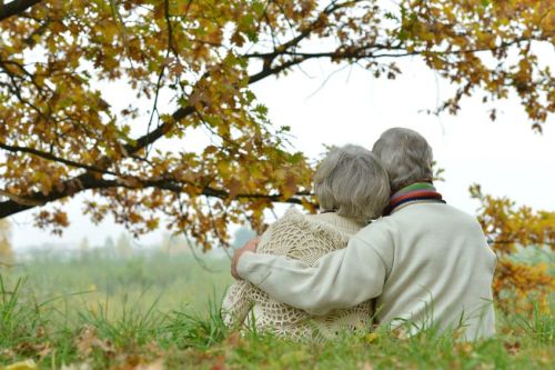 cute-elderly-couple-sitting-on-grass