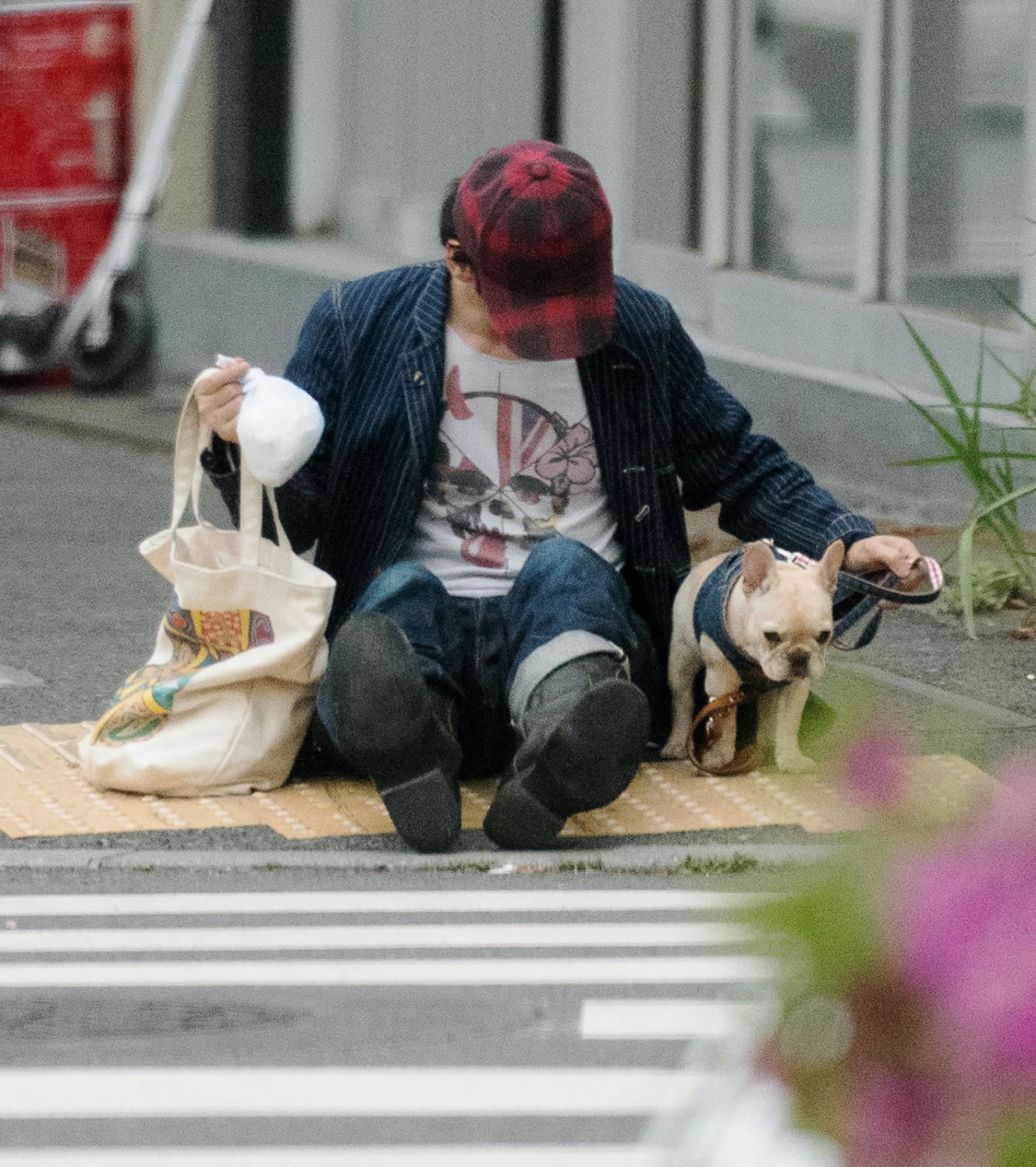 足を投げ出して大通り沿いの歩道に座り込む草彅