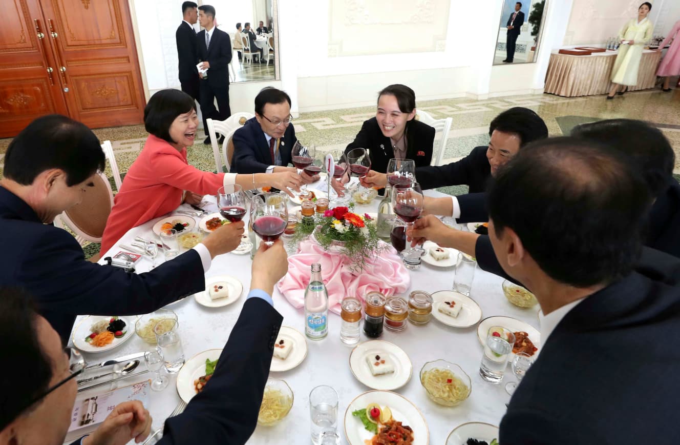 中央右上が与正氏。18年９月に行われた南北首脳会談後の昼食会で。与正氏はワイングラスを片手に笑顔で乾杯！
