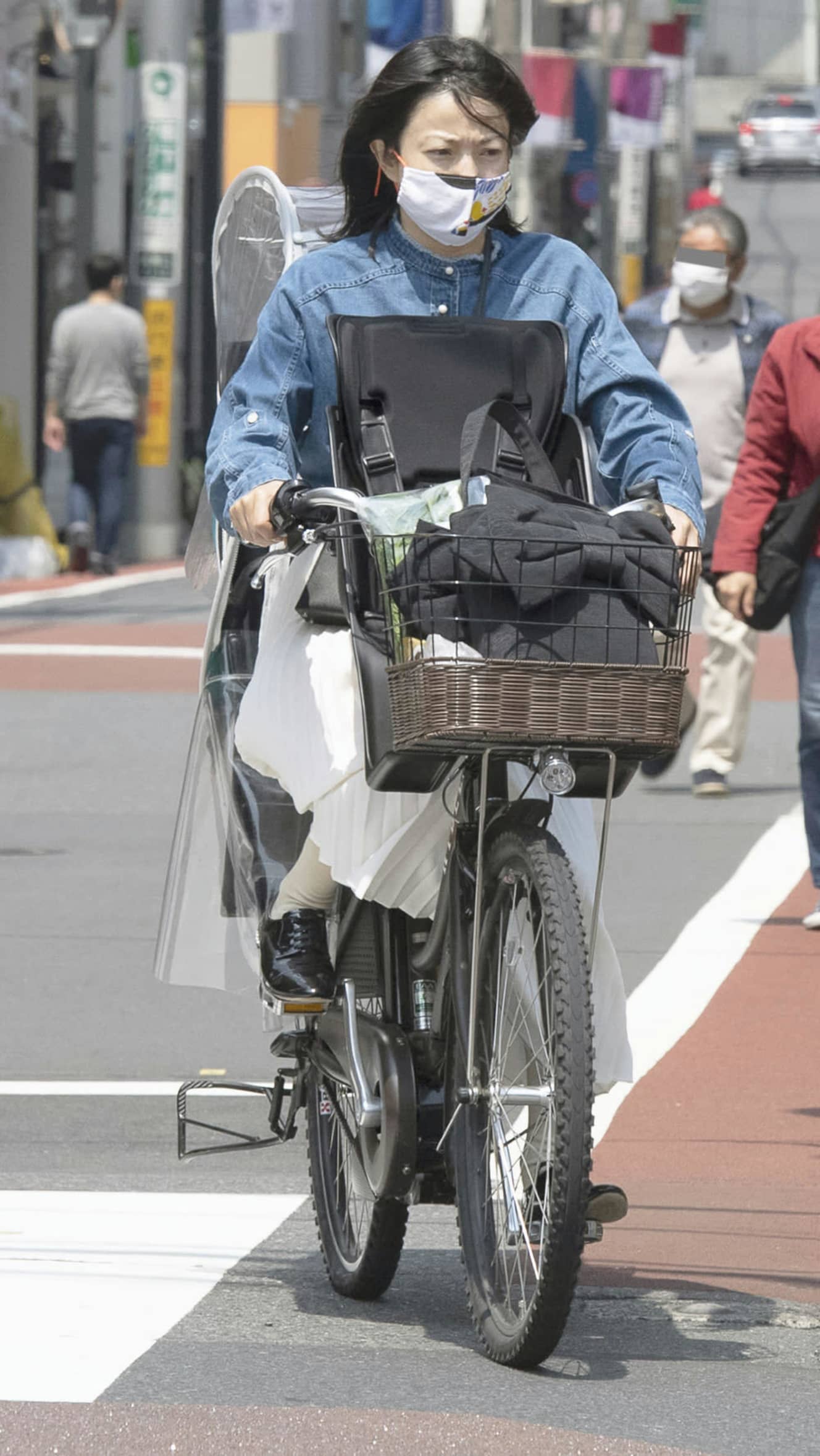 厳しい表情で自転車をこぐ菅野。妻として母親として手を抜くことはない