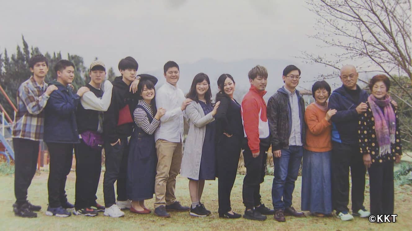 信子さん(写真右から3人目)と英治(同2人目)さん、信子さんのお母さん(同右)と10人の子どもたち(2019年3月撮影)