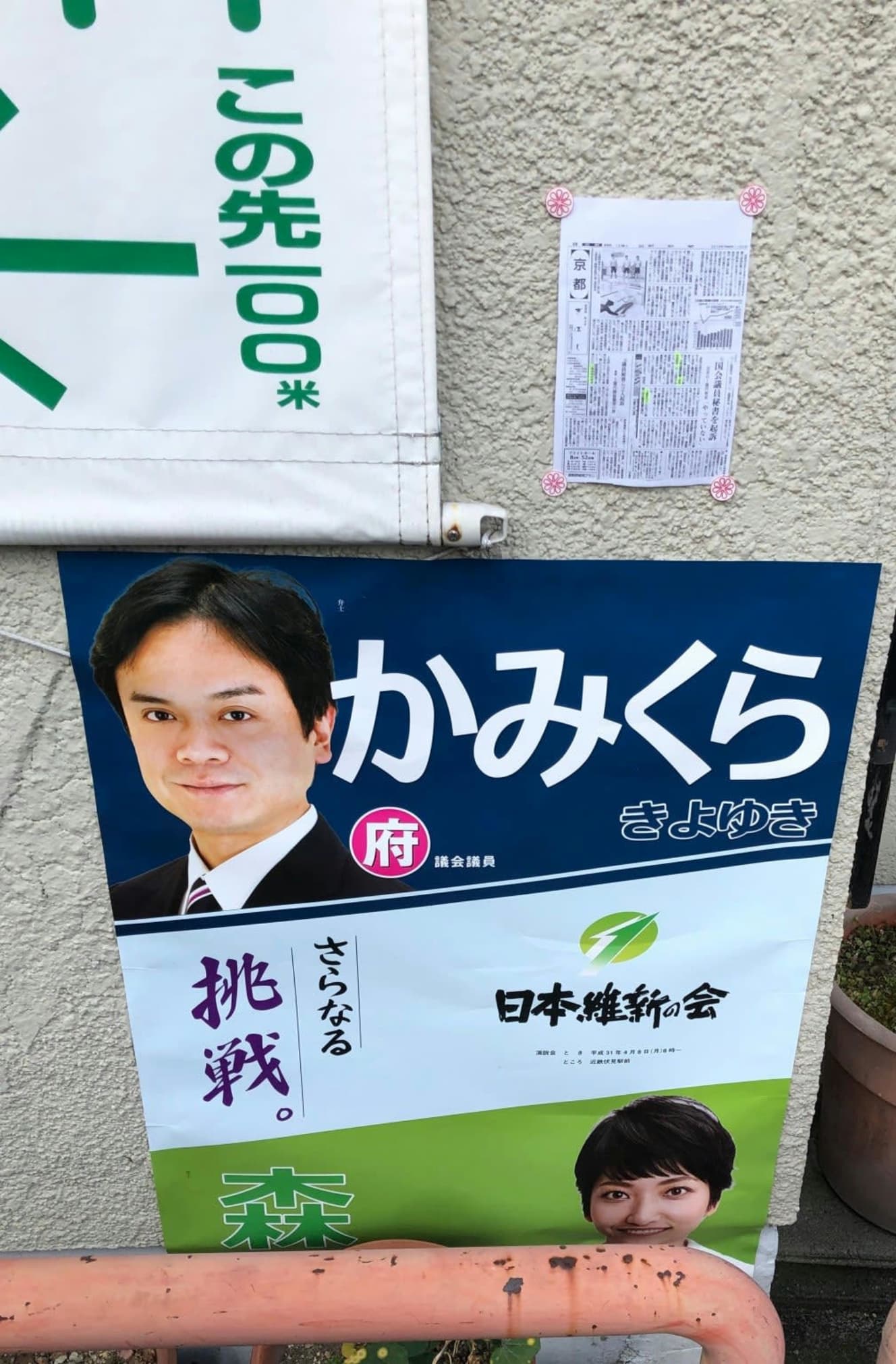 上倉議員のポスターの上に貼られている白い紙は、上倉議員に関係する新聞の切り抜きコピー。配られた「怪文書」とは別だが、はがしてもまた貼られる、という行為が繰り返されていたという(写真:京都市伏見区内の住民提供)