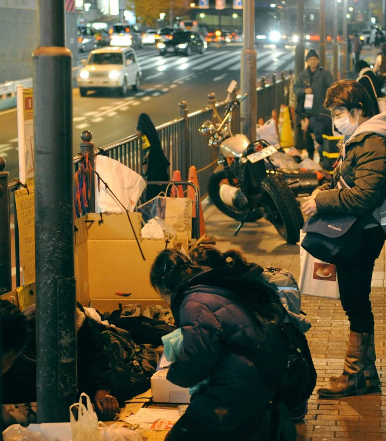 東京・新宿のホームレスたちに食事などを供給する福祉団体のスタッフたち（画像：共同通信社）