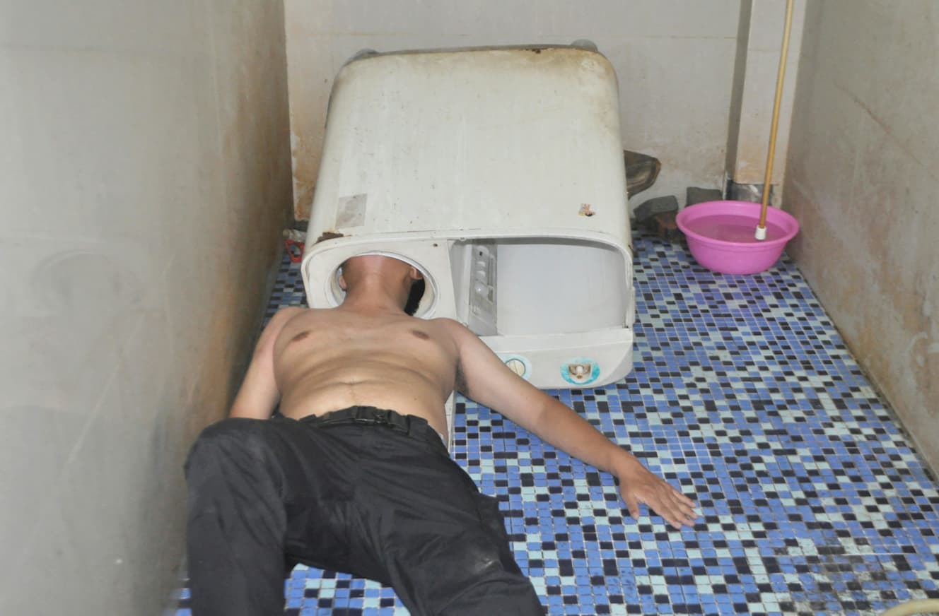なぜこうなったのか。頭を洗濯機に突っ込んで抜けなくなってしまった男性。成す術(すべ)なしと床に寝転がる