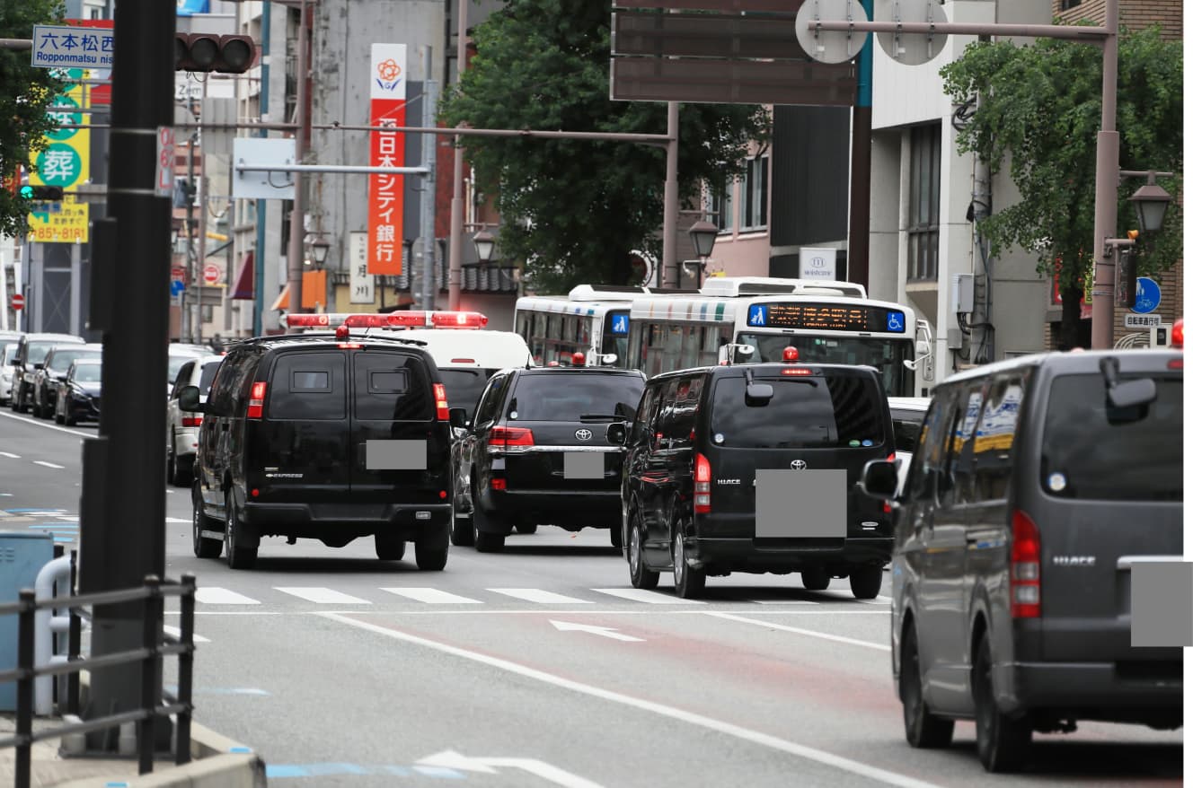 両被告の乗る護送車を囲むように走る警察車両