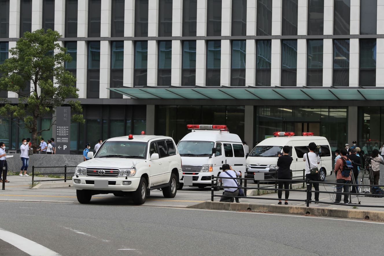 両被告の乗る護送車を囲むように走る警察車両