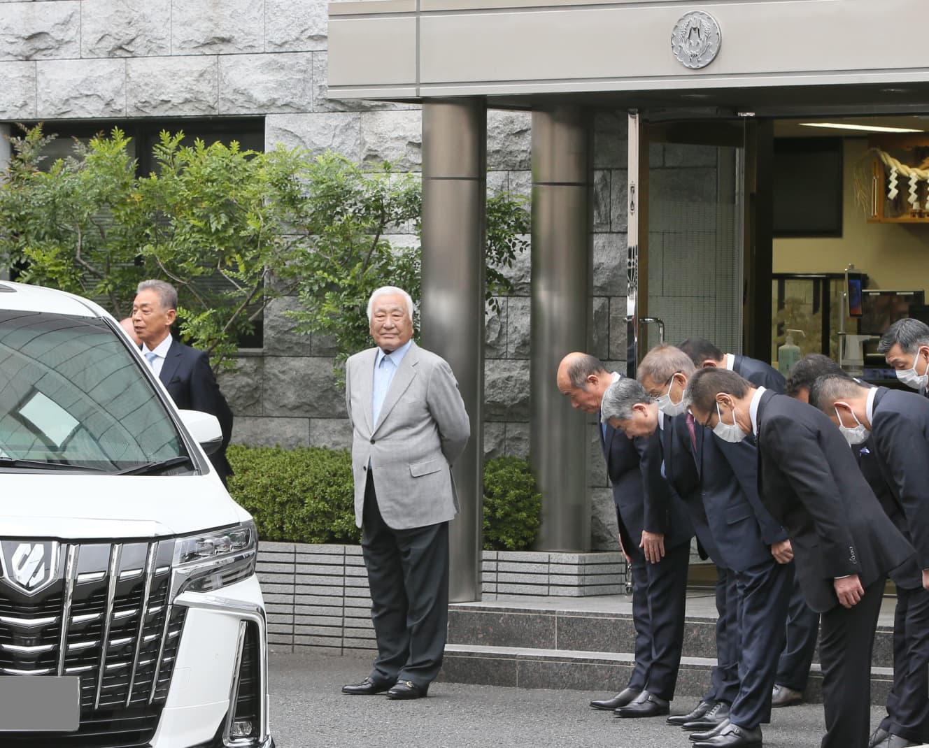 高山若頭が乗った車に向かって頭を下げる稲川会の面々。高山若頭はその後、別の会合に向かったとみられる