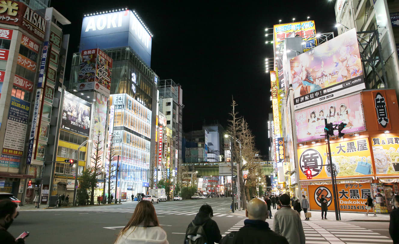 年明けの秋葉原。コロナ禍でも多くの人通りがある。交差点の角にはメイド喫茶の大きな看板が掲げられている