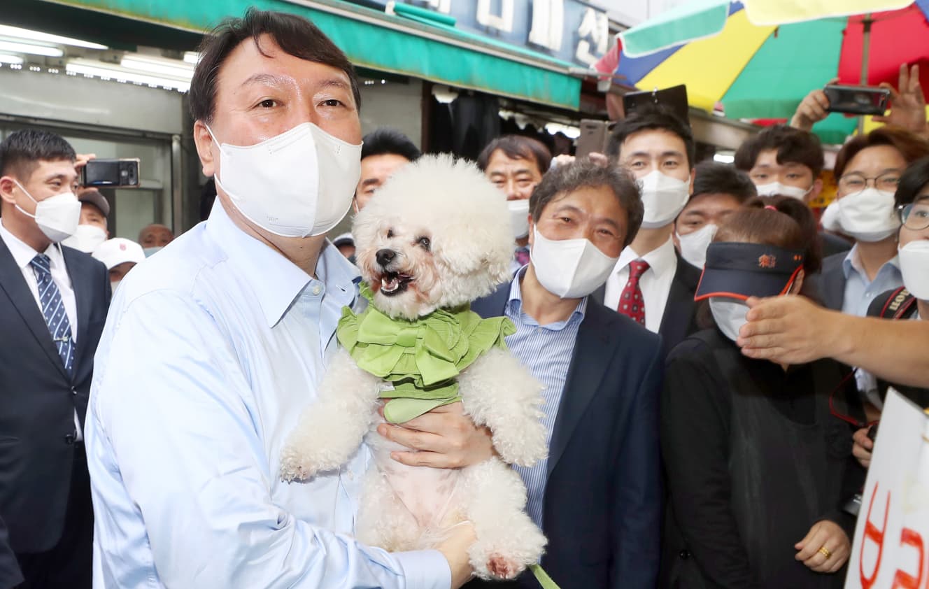 選挙活動中に訪れた市場で、思わず店主のペットを抱き上げる。動物保護にも積極的で、自身のペットも４匹は保健所から引き取ったものだという