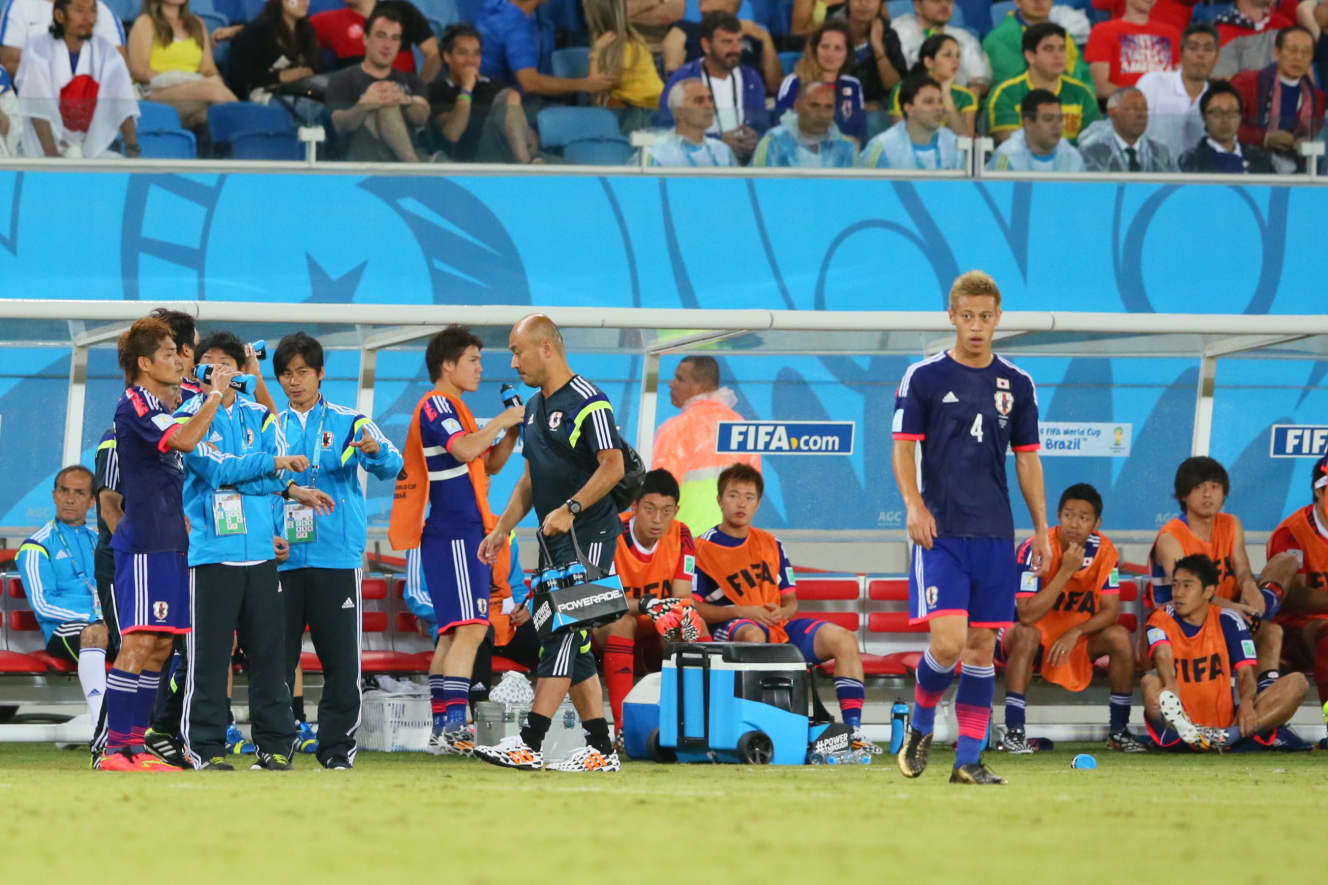 ブラジルW杯で中心的存在だった本田圭佑（背番号4）とベンチから戦況を見つめる権田（右から7番目）。権田の復活の陰に本田がいた（写真：アフロ）