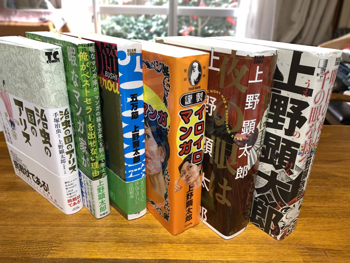 我が家にある上野顕太郎さんの著作。ウエケンの本はいちいちブ厚い。『治虫の国のアリス』は、膨大な手塚作品からネタを拾ってパロディしまくったという異常な作品（撮影：とみさわ昭仁）