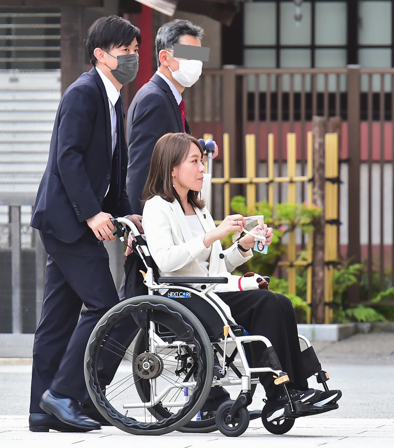 浅草寺の境内で車イスを押す橋本氏と、嬉しそうな今井氏