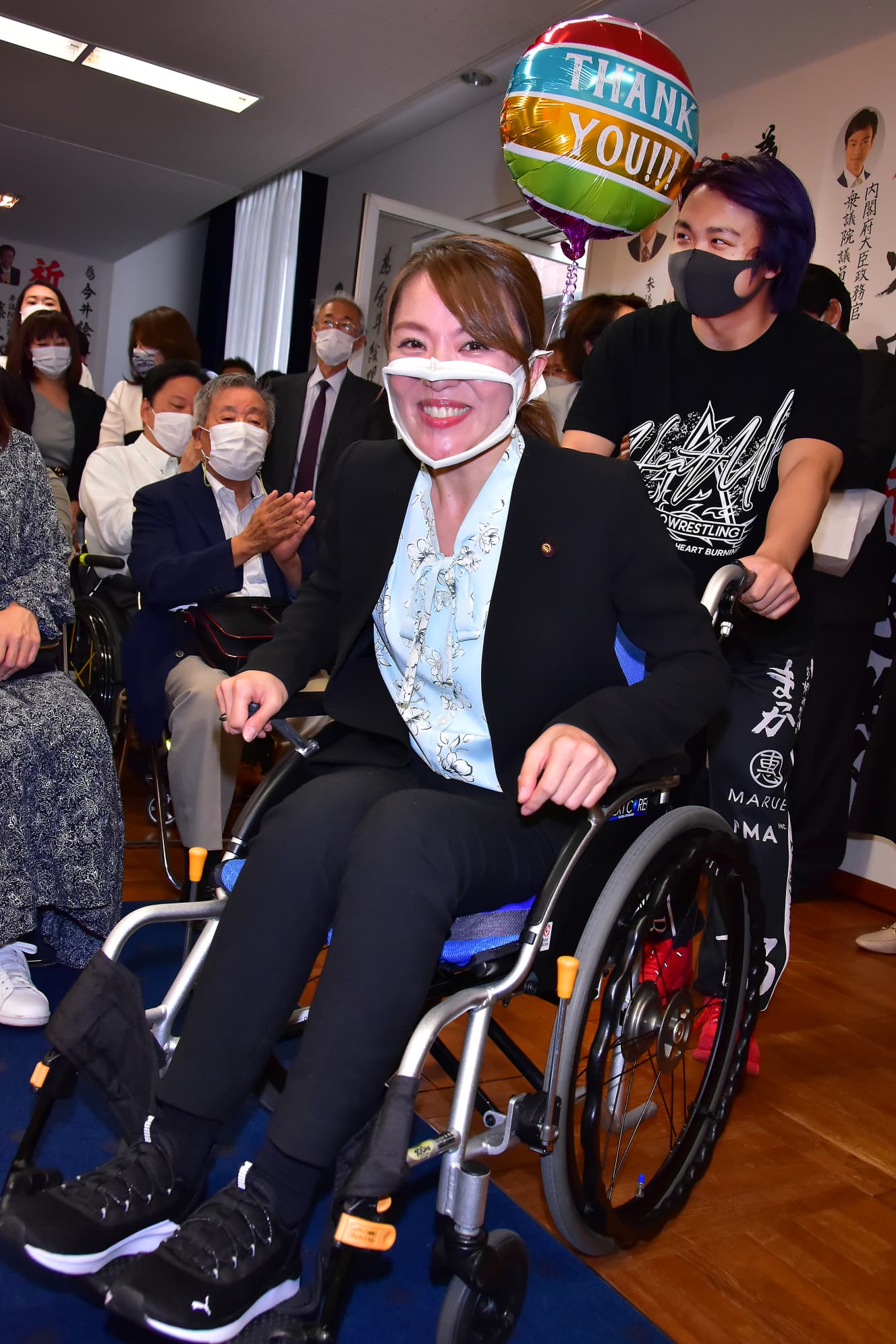 息子に車イスを押されて登場する今井氏