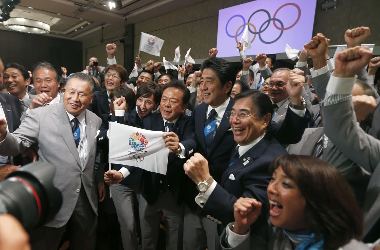 2013年9月7日、アルゼンチンで行われたIOC総会。五輪開催地に「東京」が選ばれた直後、のちにオリパラトップになる森喜朗氏の背後で高橋氏（左から２人目）も喜ぶ。当時外務大臣だった岸田総理（左端）の姿もあった（写真：ロイター/アフロ）