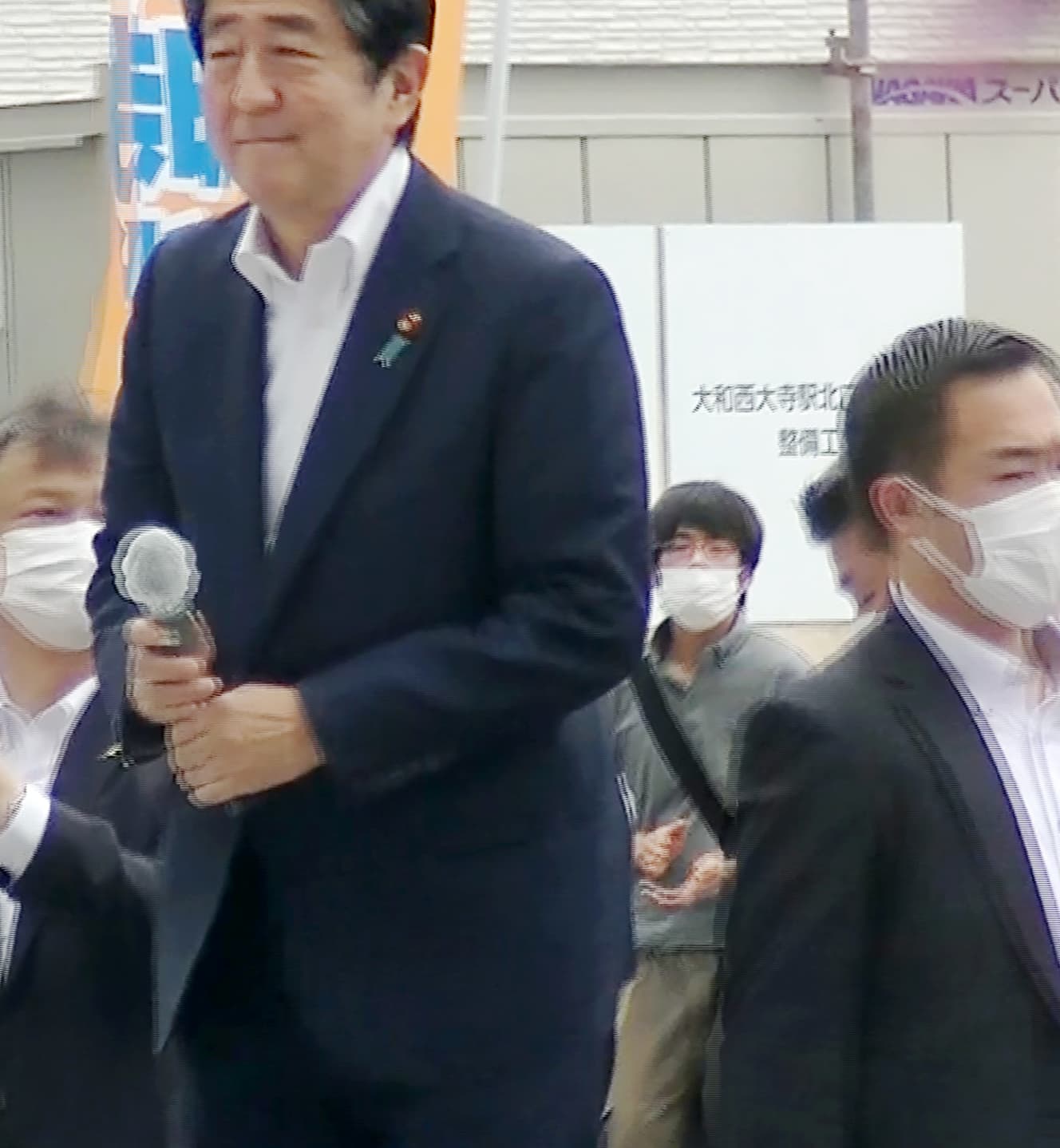 事件直前、安倍元首相の背後で犯行の機会を窺う山上容疑者。田中会長は山上家について「苦しい心を持った家庭だった」と話した