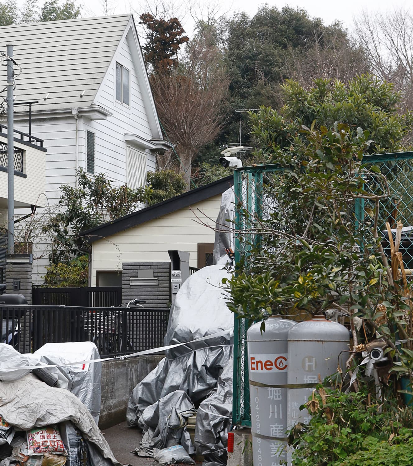 一夫多妻生活が行われていた渋谷容疑者の自宅（中央上）。敷地内には園芸用と思われる肥料が無造作に置かれる
