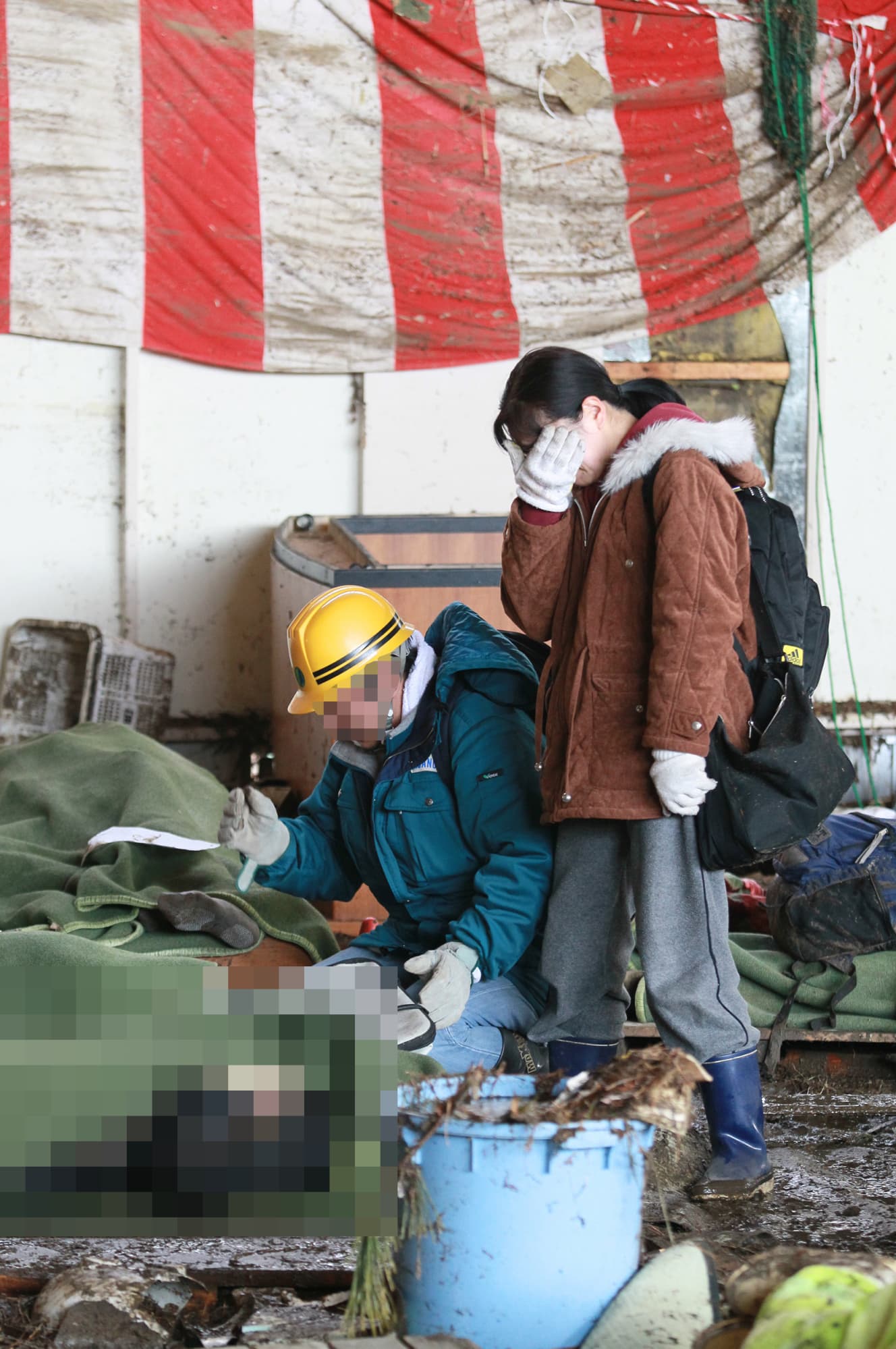 宮城県東松島市の小学校内に安置された遺体を前に涙を流す遺族（写真は一部加工しています）