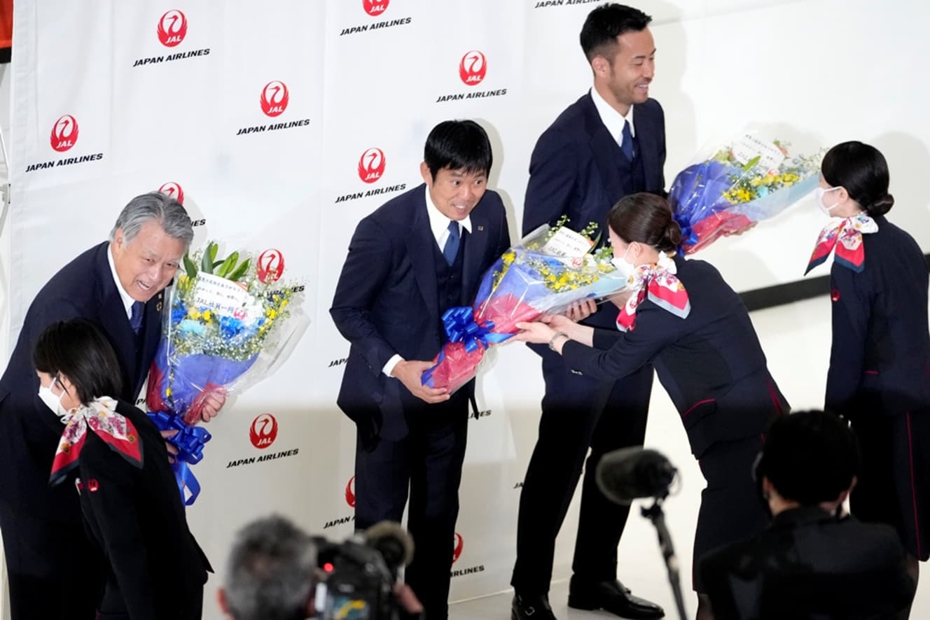 わずか２ヵ月前の昨年12月、カタールW杯を終えて帰国した後、成田空港でJALの社員から花束をもらった吉田麻也（右端）や森保一監督（中央）、田嶋会長（左、写真：アフロ）