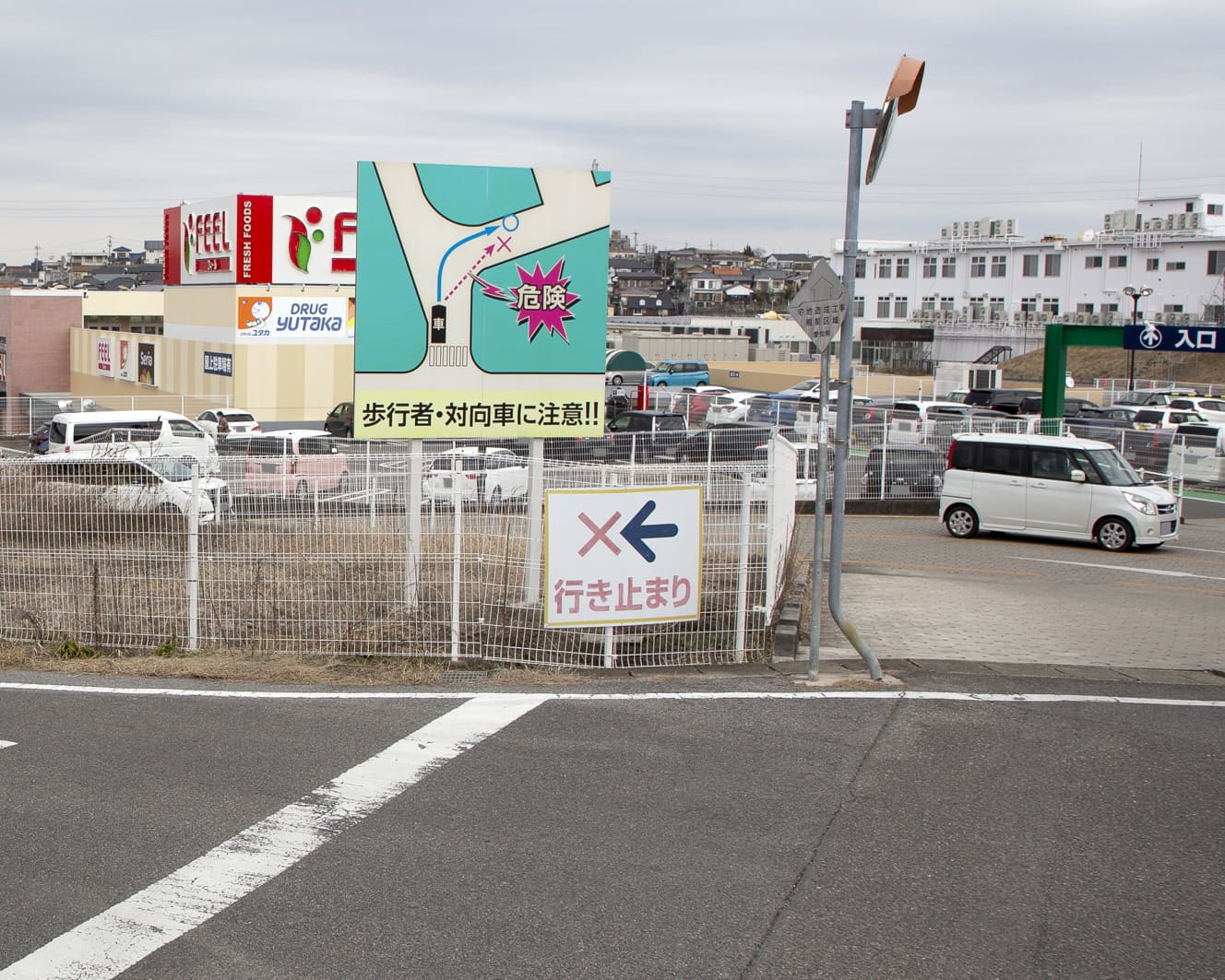 車が停められていた路地。見通しが悪く、事故が多発するスポットのため注意を促す看板が立てられている