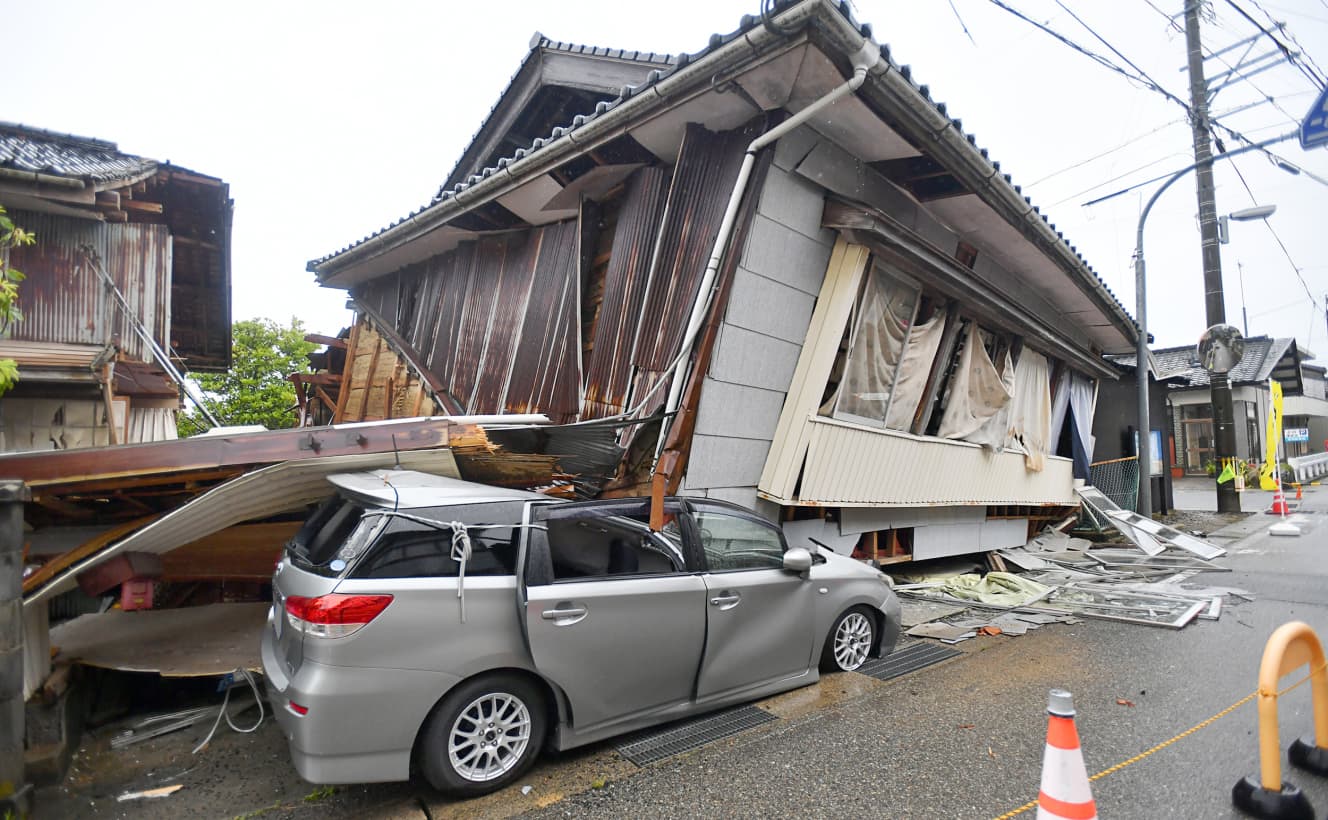 １階部分が崩れ近くに停まっていた車を押しつぶした家屋。珠洲市宝立町