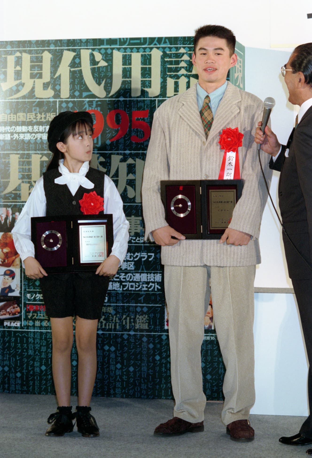 「同情するならカネをくれ」のセリフで’94年の流行語大賞を受賞した安達（左）。同じく大賞のイチローを見上げる（PHOTO：時事通信社）