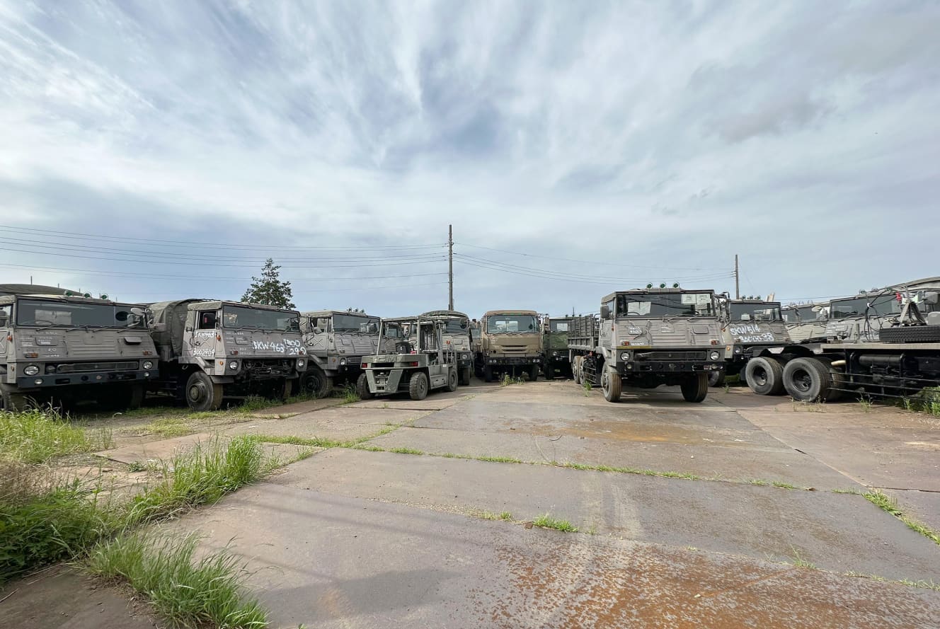 約30台の軍用車両が所狭しと並ぶ駐車場には防犯カメラが設置されているが、中に入ろうとするマニアがいる（撮影：加藤博人）