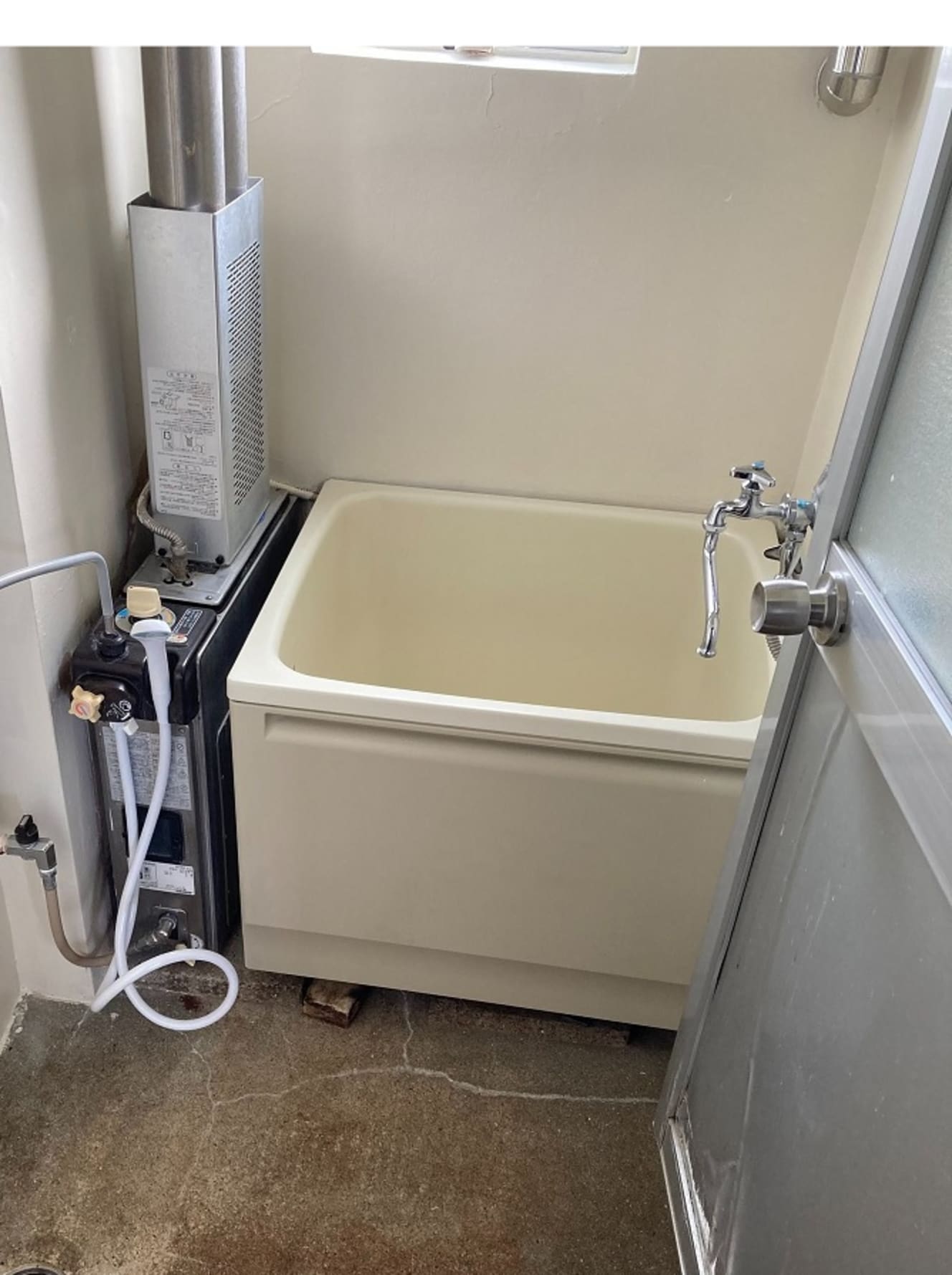 自衛隊官舎で見かける昭和の遺物・バランス釜。狭い浴槽の横にある装置で温水をつくる